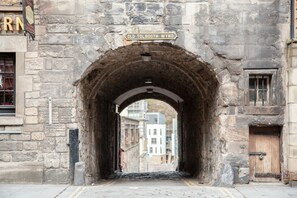 An arched stone tunnel with a sign reading "Old Tolbooth Wynd."