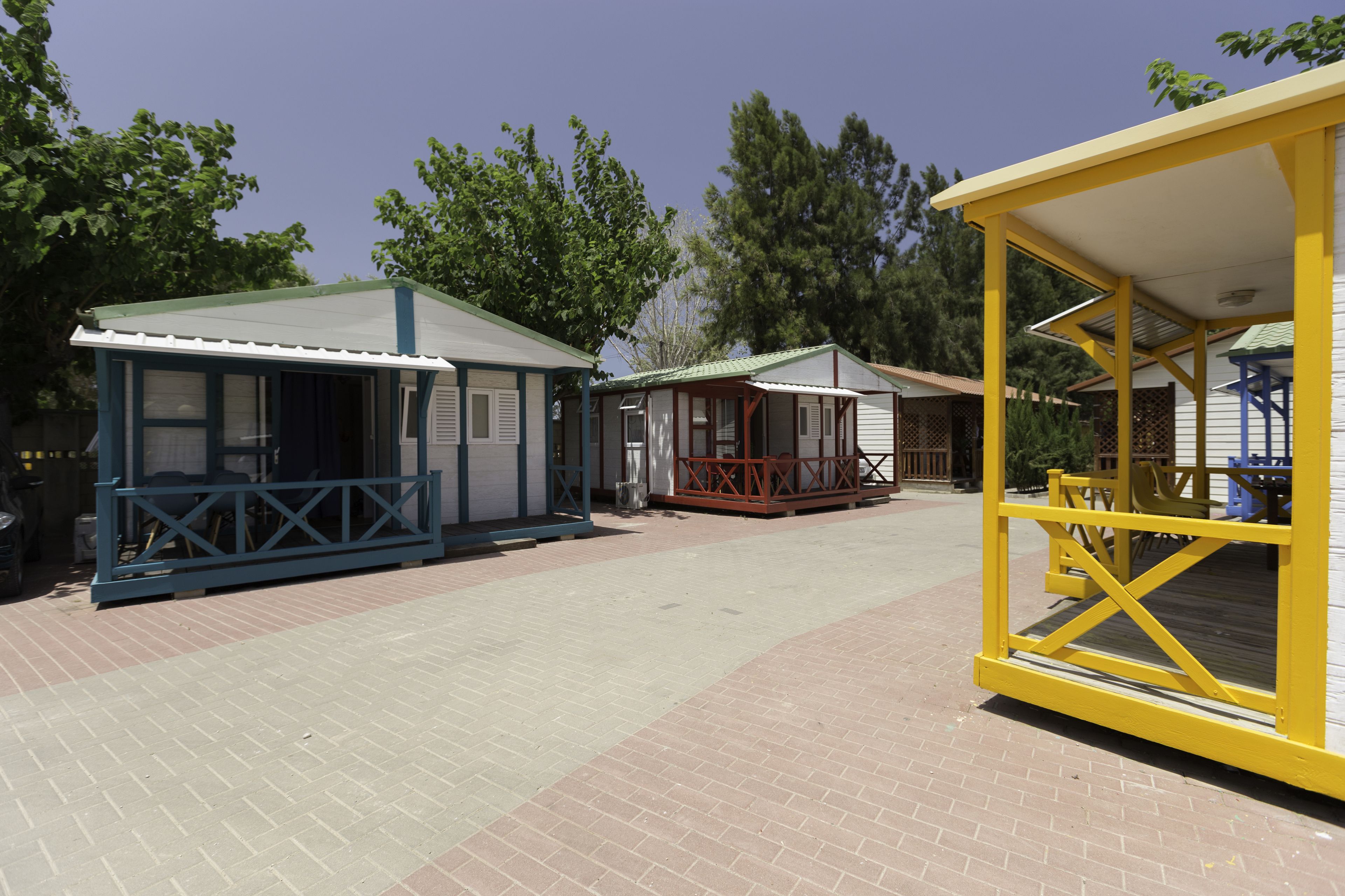 A row of small, single-story cabins with a covered porch area.