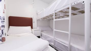 Une chambre avec un lit superposé, un matelas blanc, une tête de lit marron et un mur blanc.