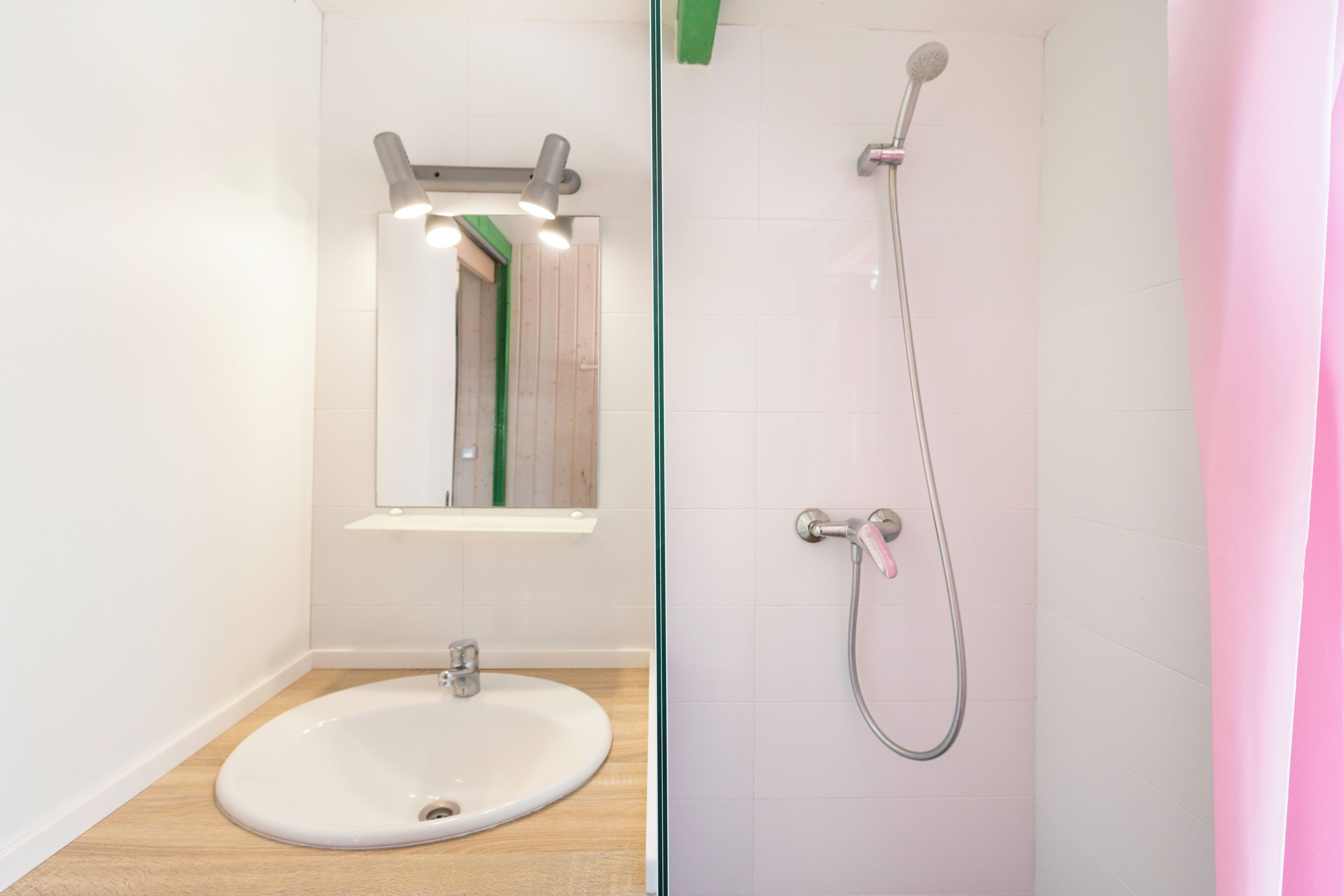 Un baño con lavabo, espejo y ducha.