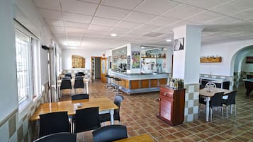 A restaurant with multiple dining areas, a bar, and a counter with beverages.