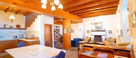A cozy wooden interior with a dining area, kitchen, and living room.