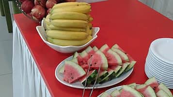 Una mesa de buffet con platos de sandía en rodajas y plátanos.
