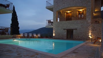 Una piscina al aire libre de temporada, sombrillas