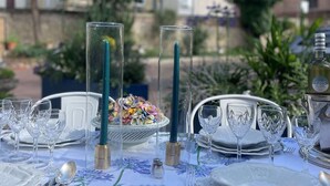 An outdoor dining setup with a table set for a meal, featuring clear glassware, plates, and a decorative centerpiece. - Chateau des Jacobins (Agen)