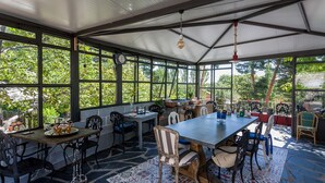A covered patio with a dining table, chairs, and a clock. - El Torreón de Navacerrada (Navacerrada)