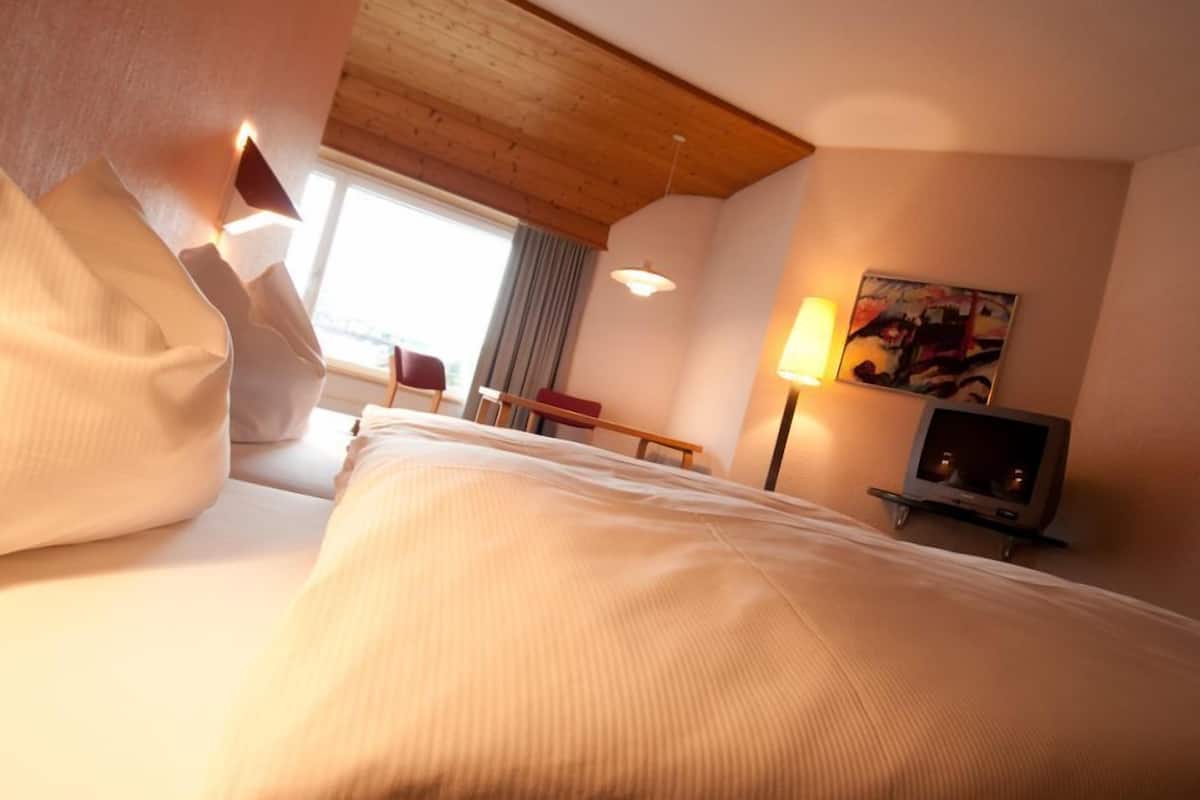 Ropa de cama hipoalergénica y caja de seguridad en la habitación