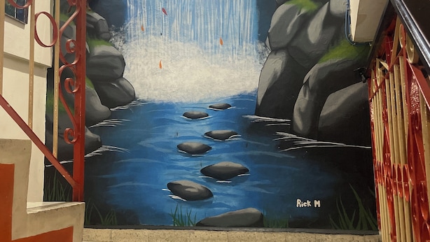 A staircase with a mural of a waterfall and rocks. - Tamarindo hostel (San Pedro Sula)