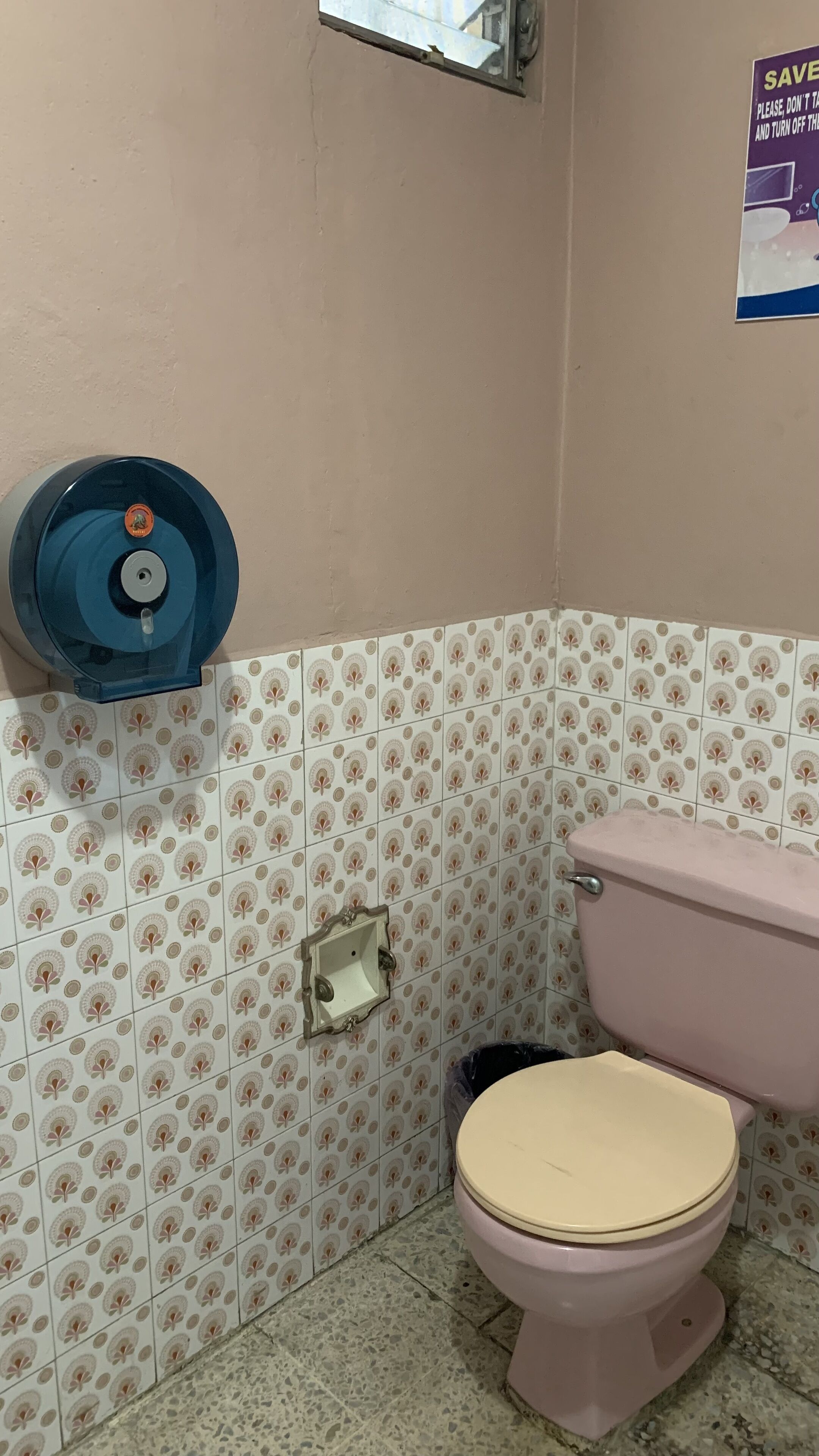 A bathroom with a toilet, a sink, and a blue hand dryer mounted on the wall.