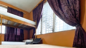 A room with a bunk bed, a window with purple curtains, and a patterned carpet. - Tamarindo hostel (San Pedro Sula)