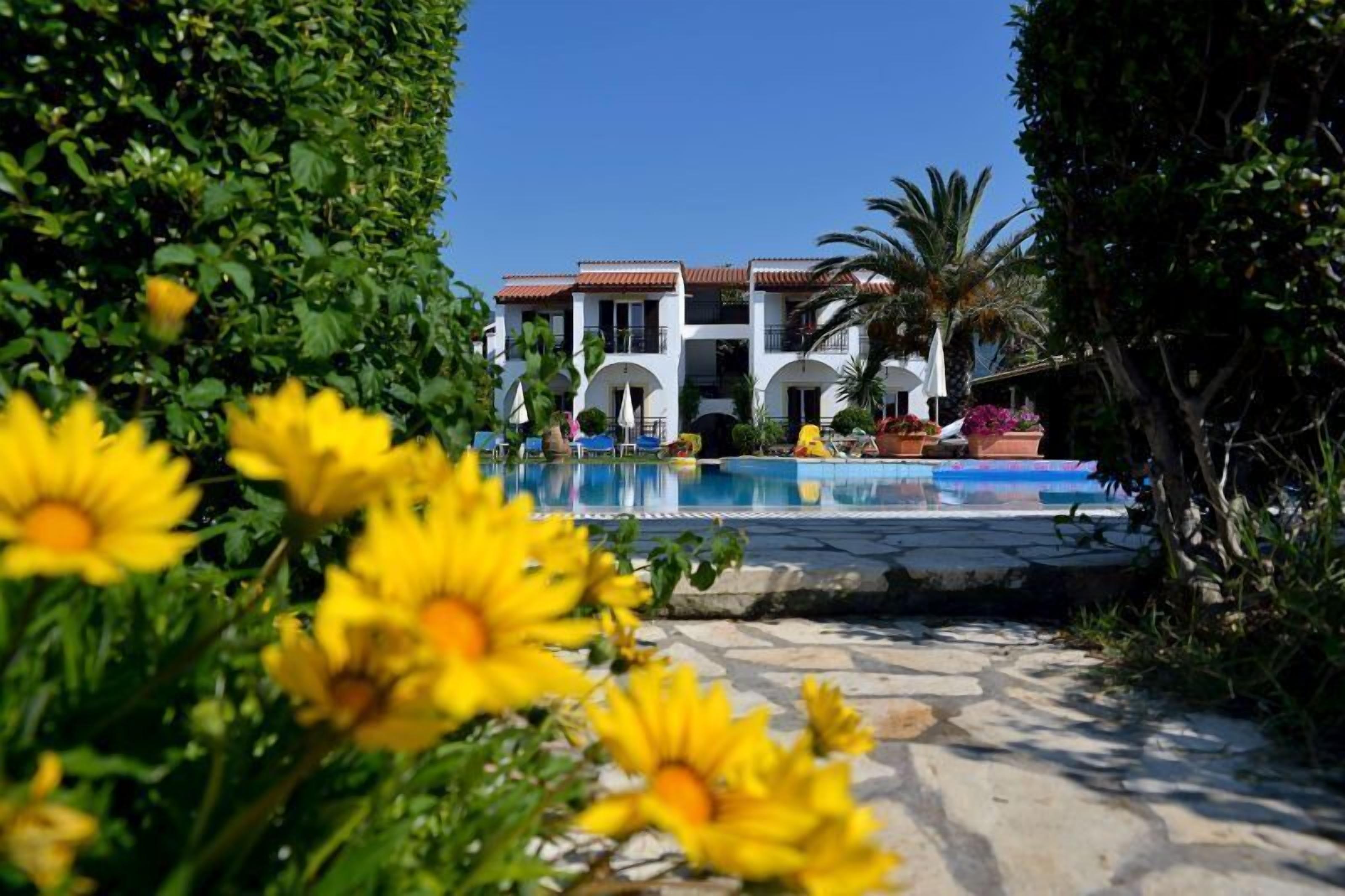 A pool area with a clear view of a building with multiple balconies and a tiled roof.