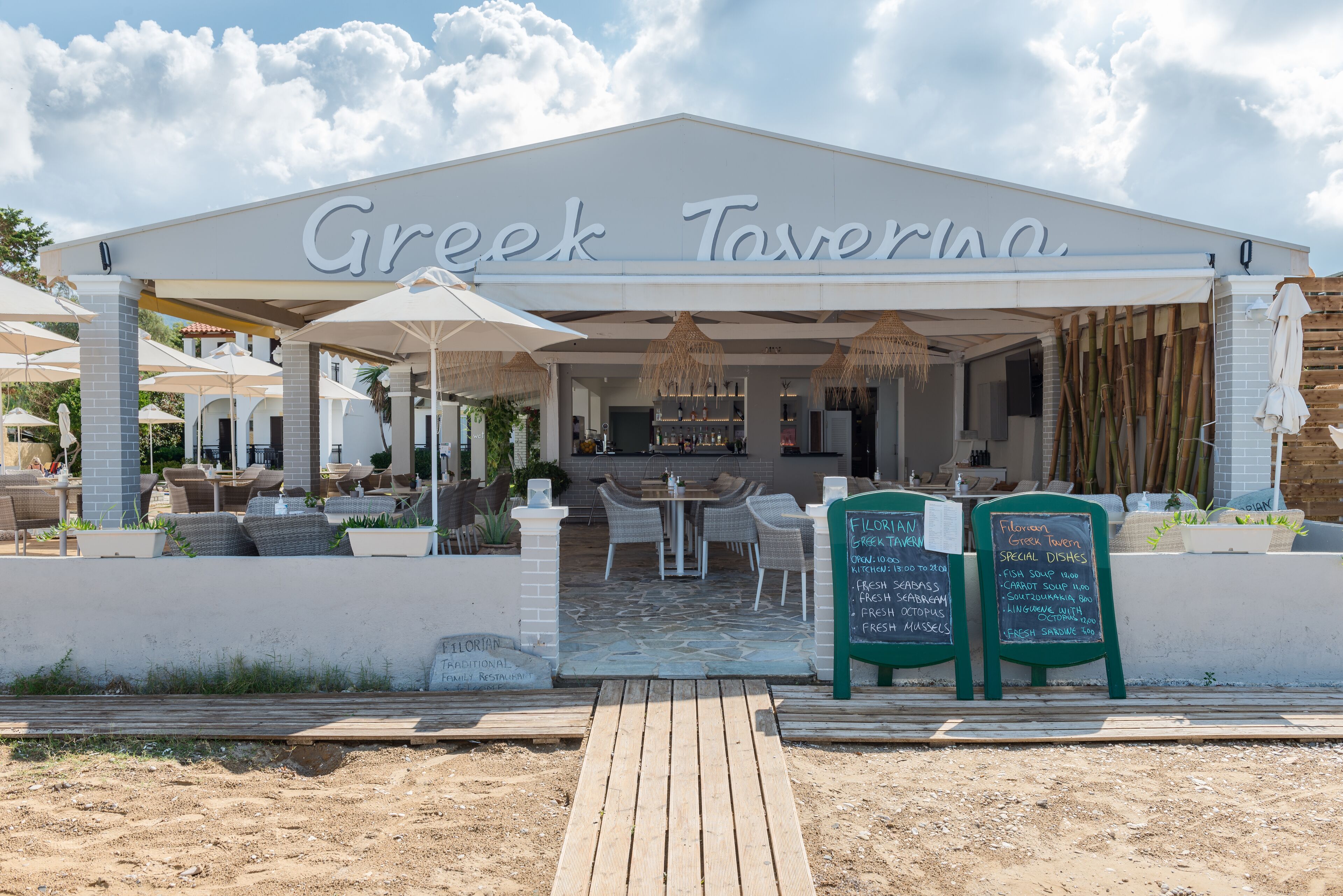 A Greek tavern with outdoor seating and a covered patio.
