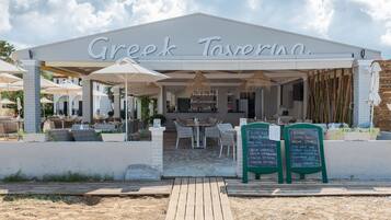 A Greek tavern with outdoor seating and a covered patio.