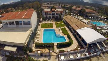 Una piscina al aire libre, sombrillas, tumbonas