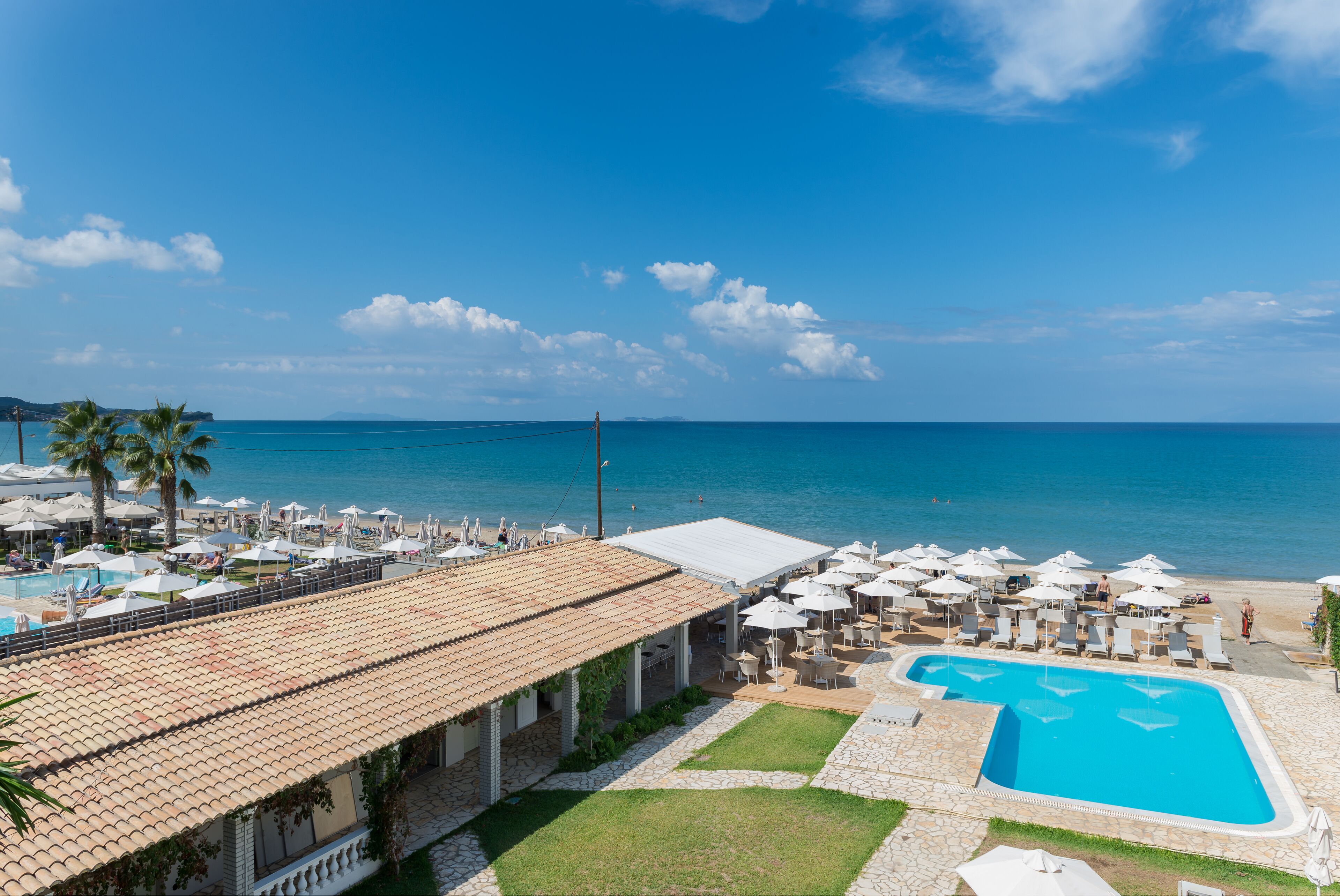 Un resort con piscina, sombrillas de playa y vistas al océano.