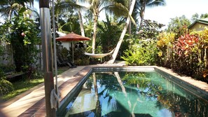 Alberca al aire libre, sombrillas en la alberca y camastros