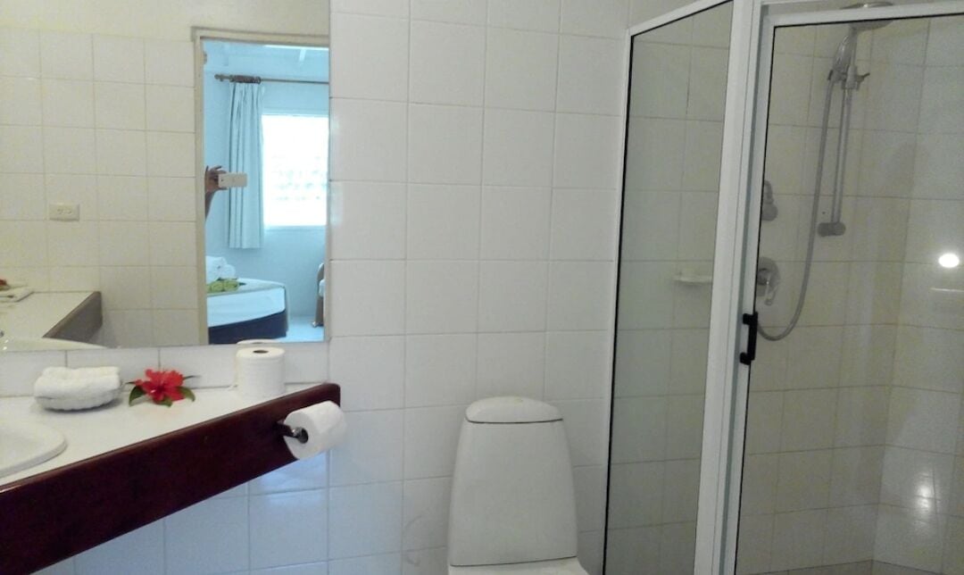 Un baño con ducha, inodoro y lavabo.