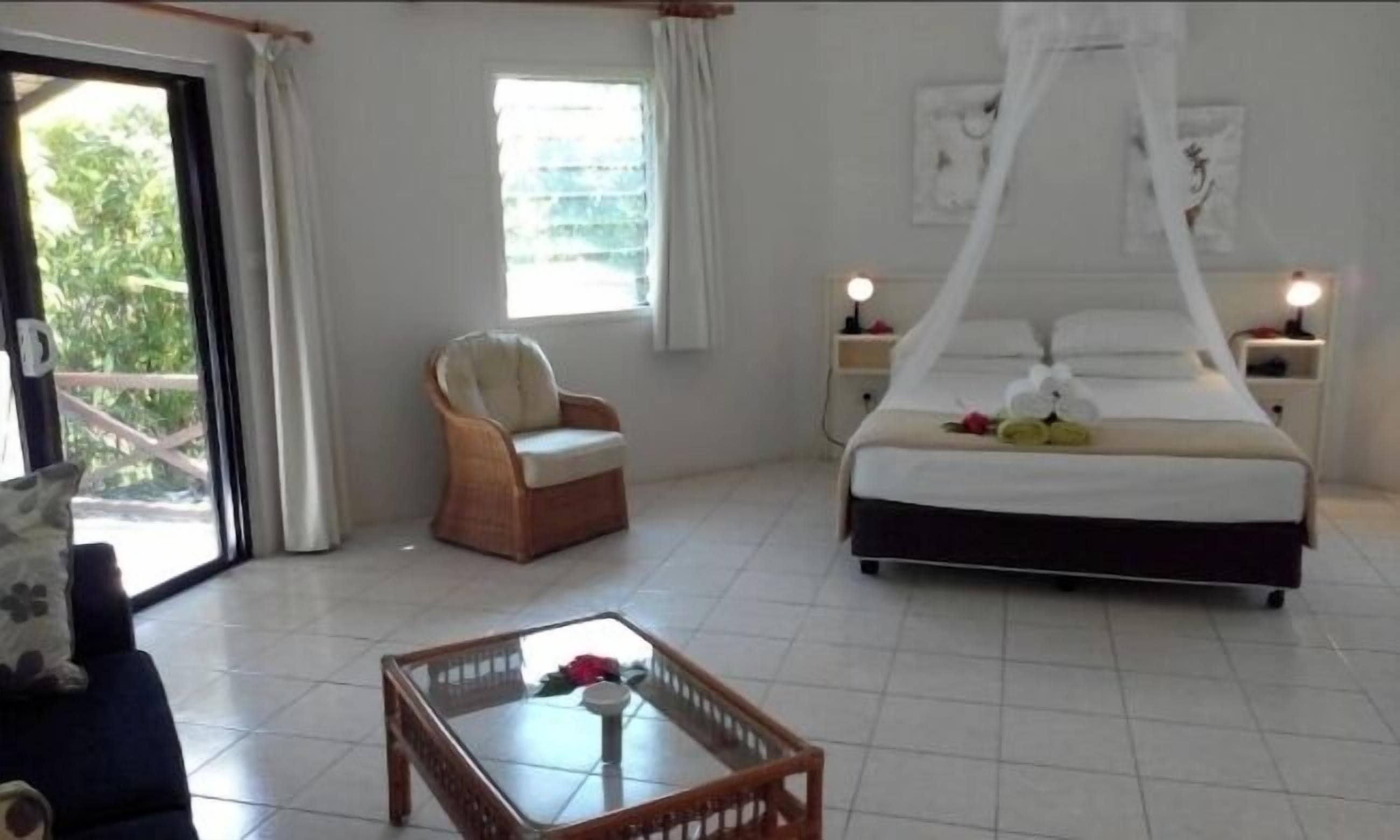 Una habitación de hotel con cama, una silla, una mesa y una ventana.