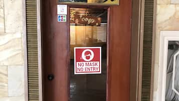 A wooden door with a sign reading "Healing Stone Spa" and a "No Mask No Entry" sign.