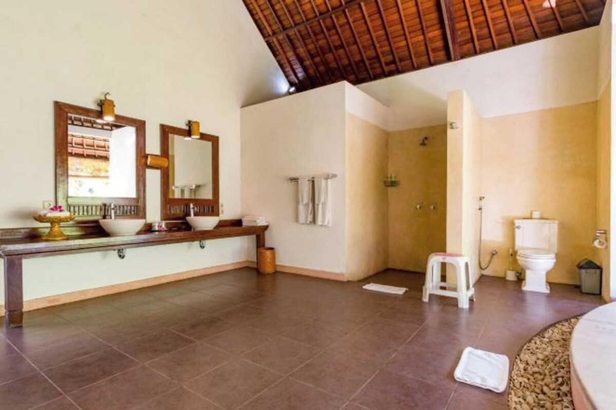 A bathroom with a shower, toilet, and sink.