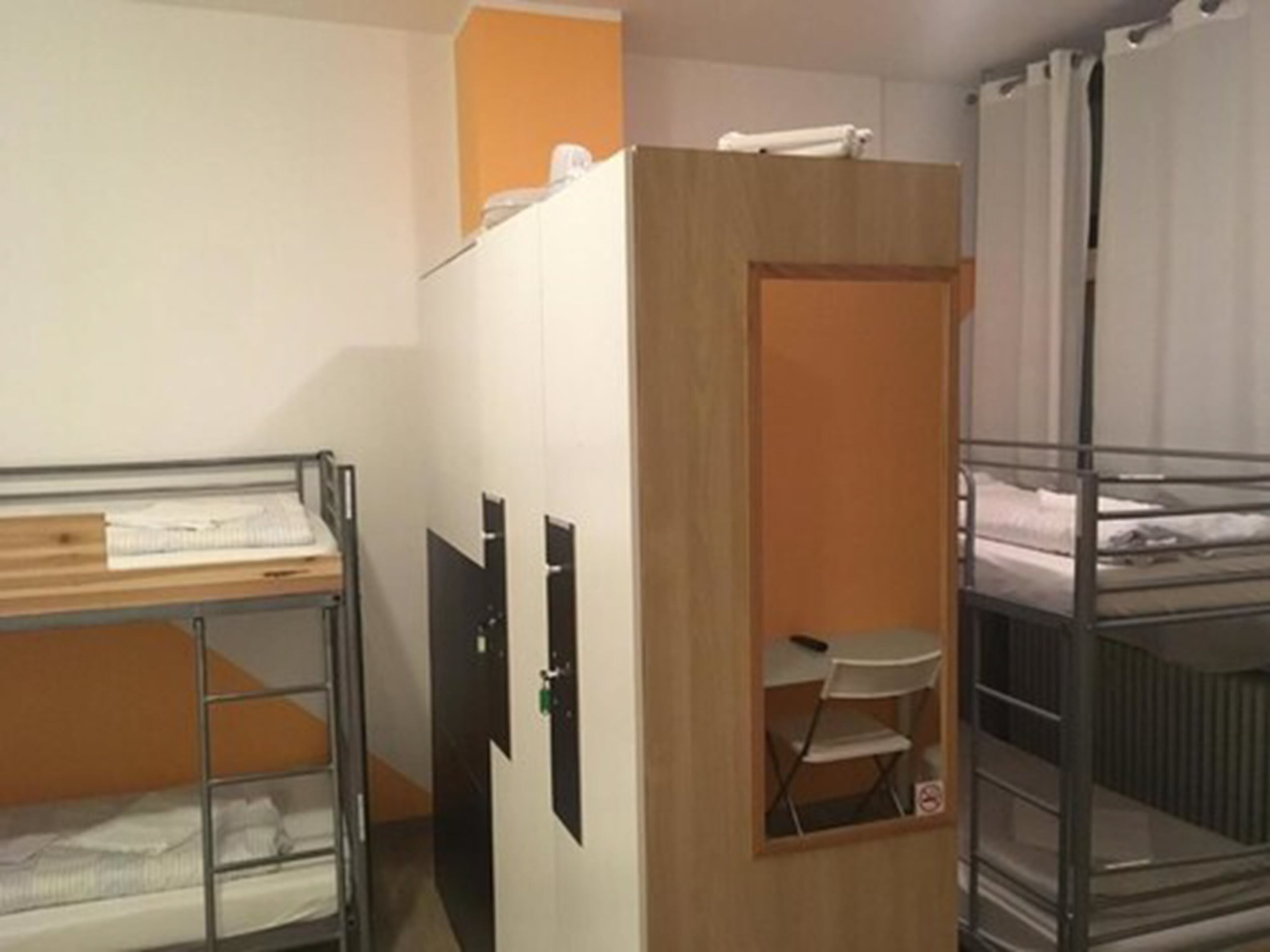 Un dormitorio con literas, un escritorio y un armario.
