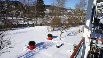 Un paysage enneigé avec un bâtiment au premier plan et une rivière en arrière-plan.