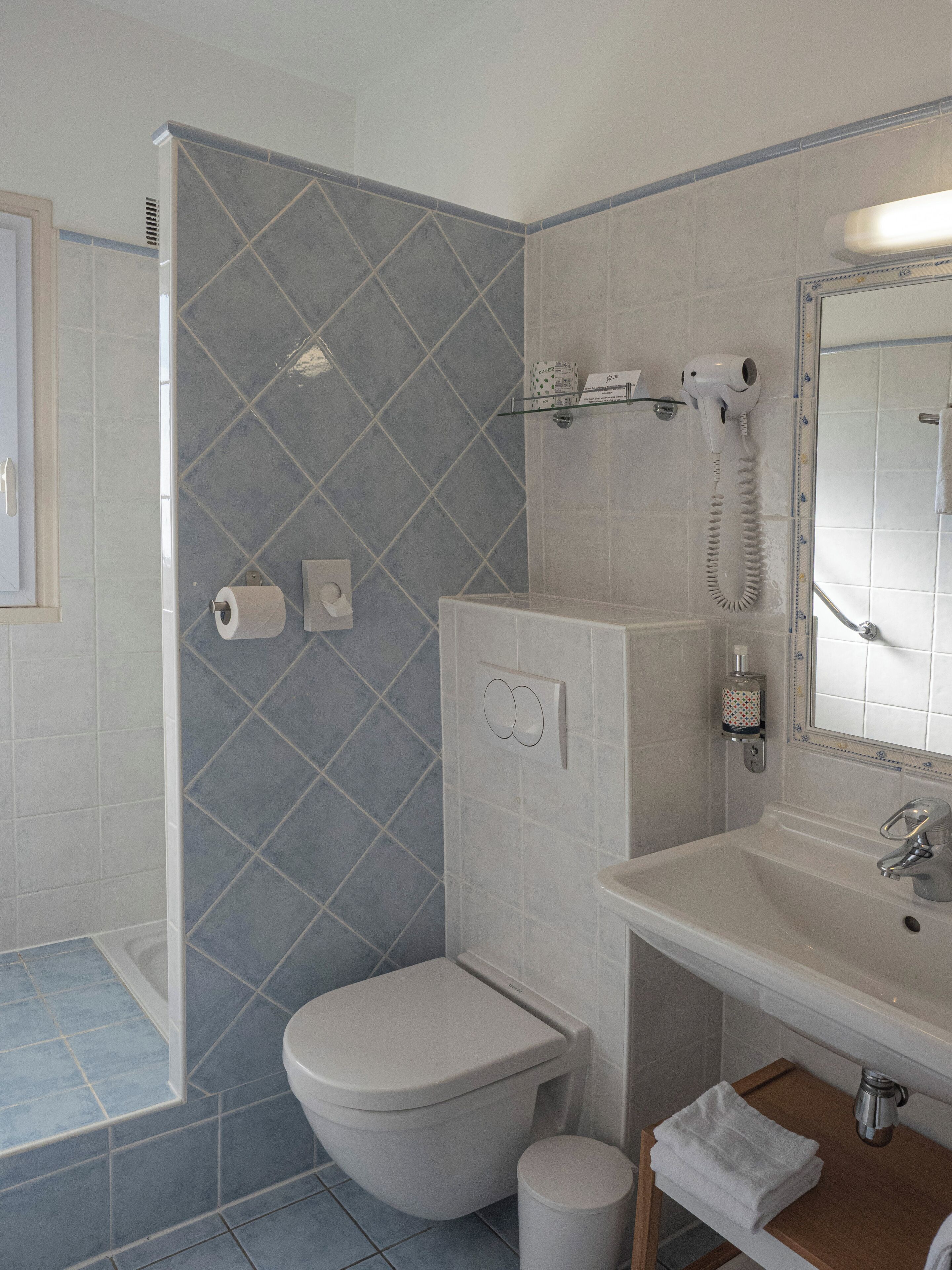 A bathroom with a toilet, sink, and shower.