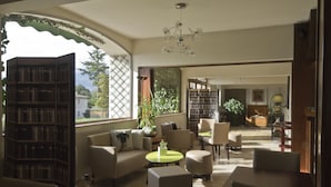 A spacious living room with a large bookshelf, comfortable seating, and a view of the outdoors. - Les Oliviers (Fayence)