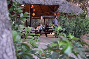 A covered picnic area with benches and tables, surrounded by greenery. - Canado Family Hotel (Castagneto Carducci)