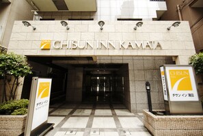 The entrance to Chisun Inn Kamata with a tiled floor and a signboard.