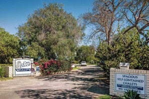 Une enseigne indiquant l’emplacement des chalets Emu Beach, des logements spacieux et indépendants, sans aspirateur, et avec une allée bien dégagée.