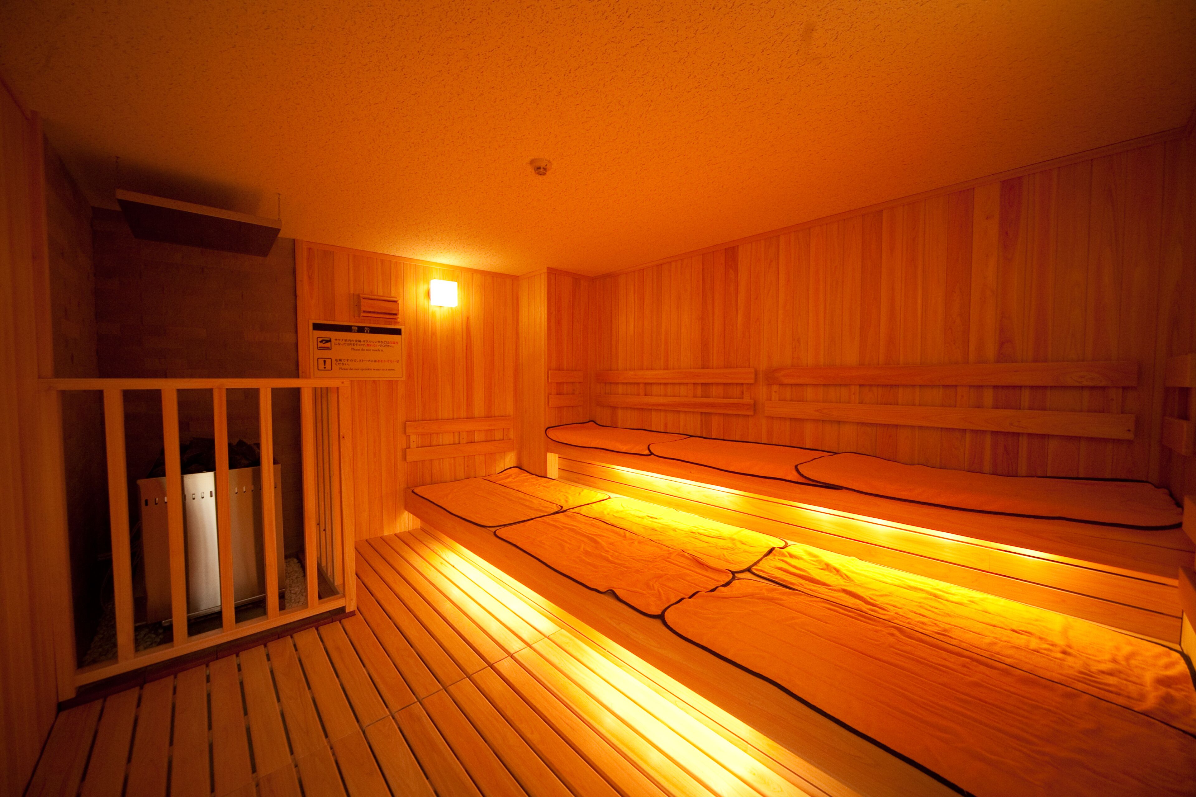 A sauna room with wooden benches and a glass partition.