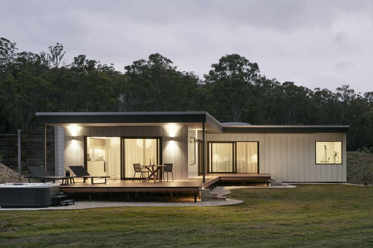 A modern house with a patio, outdoor seating, and a hot tub.
