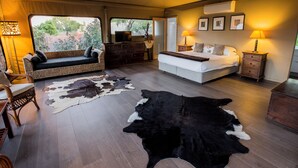 A tented room with a bed, a sofa, a dresser, and a cowhide rug. - The Billi Resort (Cable Beach)