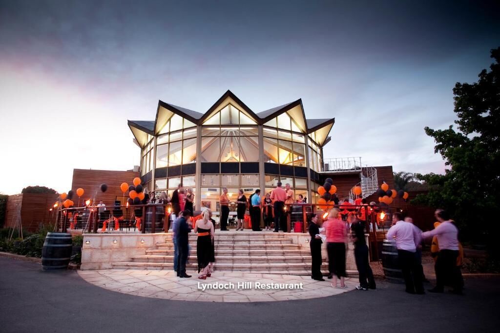 The exterior of Lyndoch Hill Restaurant with a modern glass facade and a circular seating area.