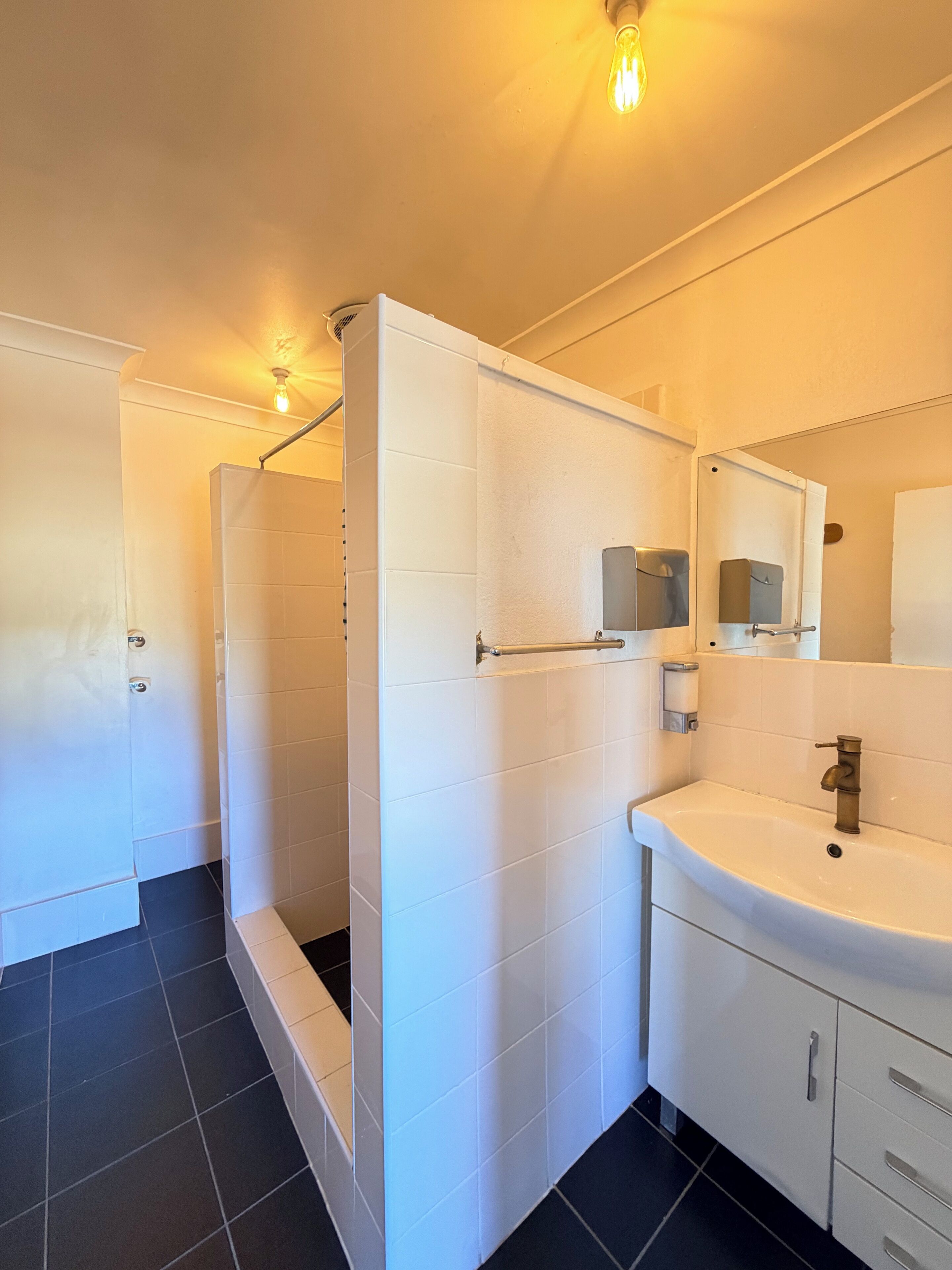 Ein modernes Badezimmer mit Dusche, Waschbecken und Spiegel.