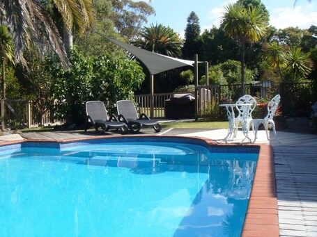 Outdoor pool, open 9:00 AM to 10:00 PM, pool umbrellas, pool loungers. Colonial House Motel