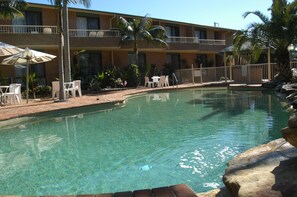 Una piscina al aire libre, tumbonas