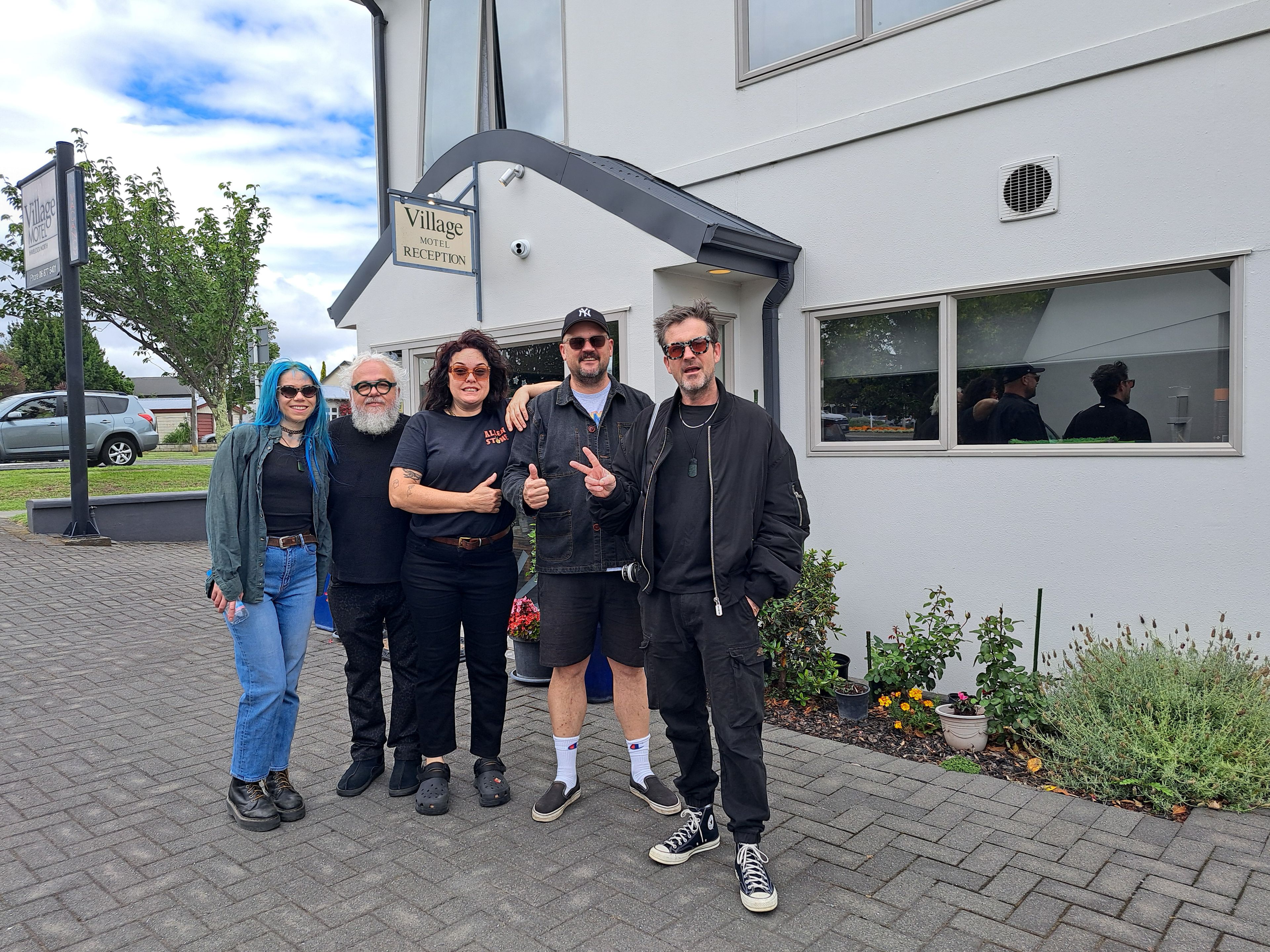 A group of people standing in front of a building with a reception sign.