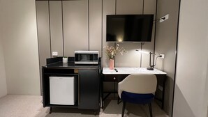 A compact office space with a desk, chair, microwave, and a flat-screen TV mounted on the wall. - Lismore City Motor Inn (Lismore)