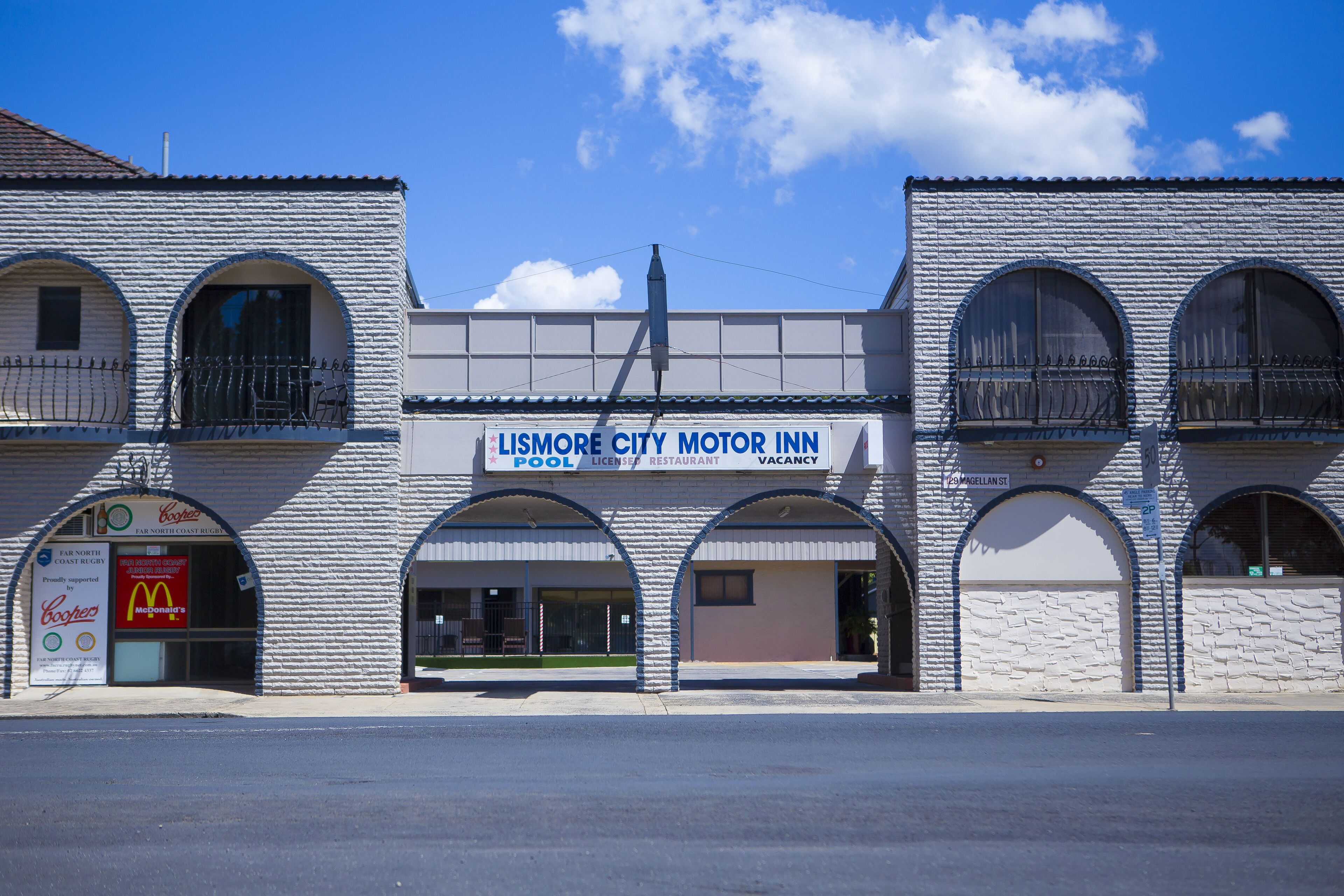Un edificio con insegna del Lismore City Motor Inn, con piscina, targa automobilistica e ristorante.