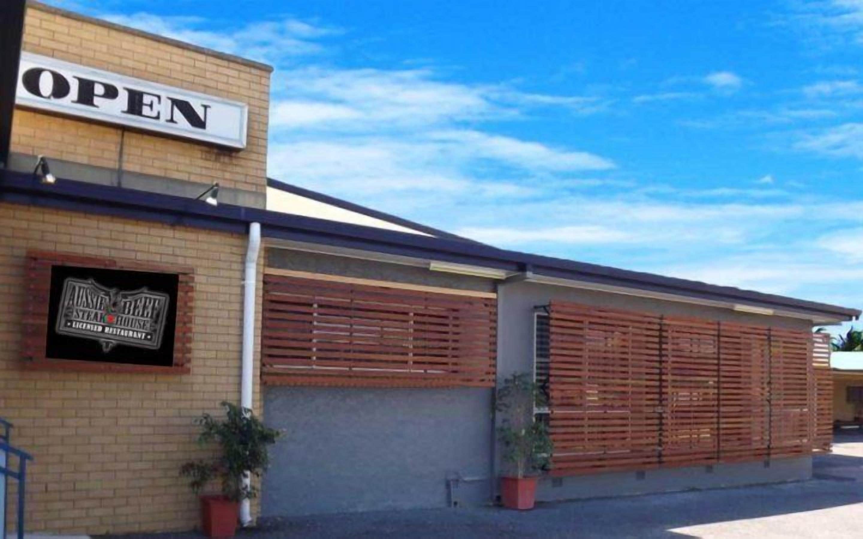 Edifici de maó amb un rètol que diu “OPEN” i el logotip d'