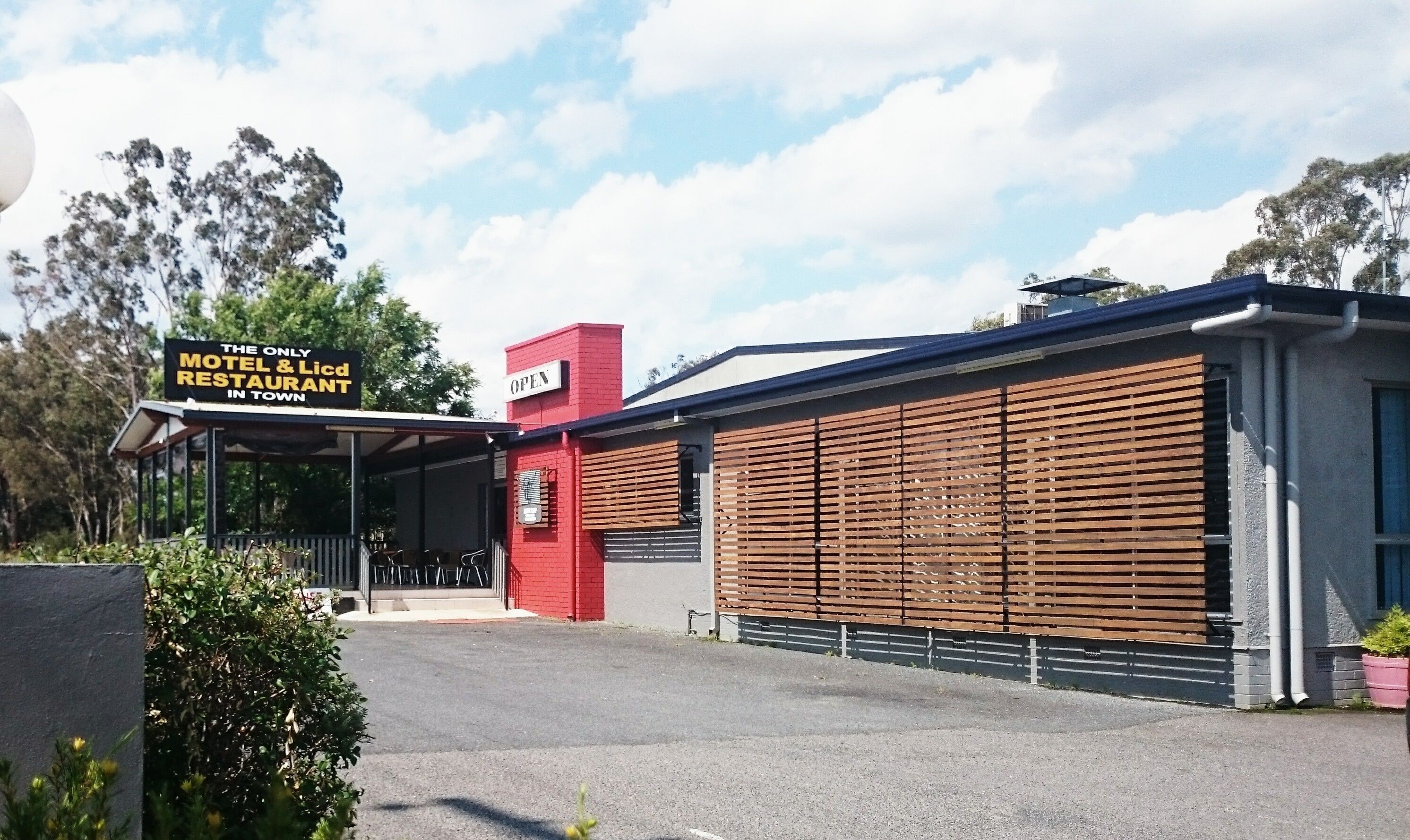 A modern building with a sign indicating it's a motel and restaurant.