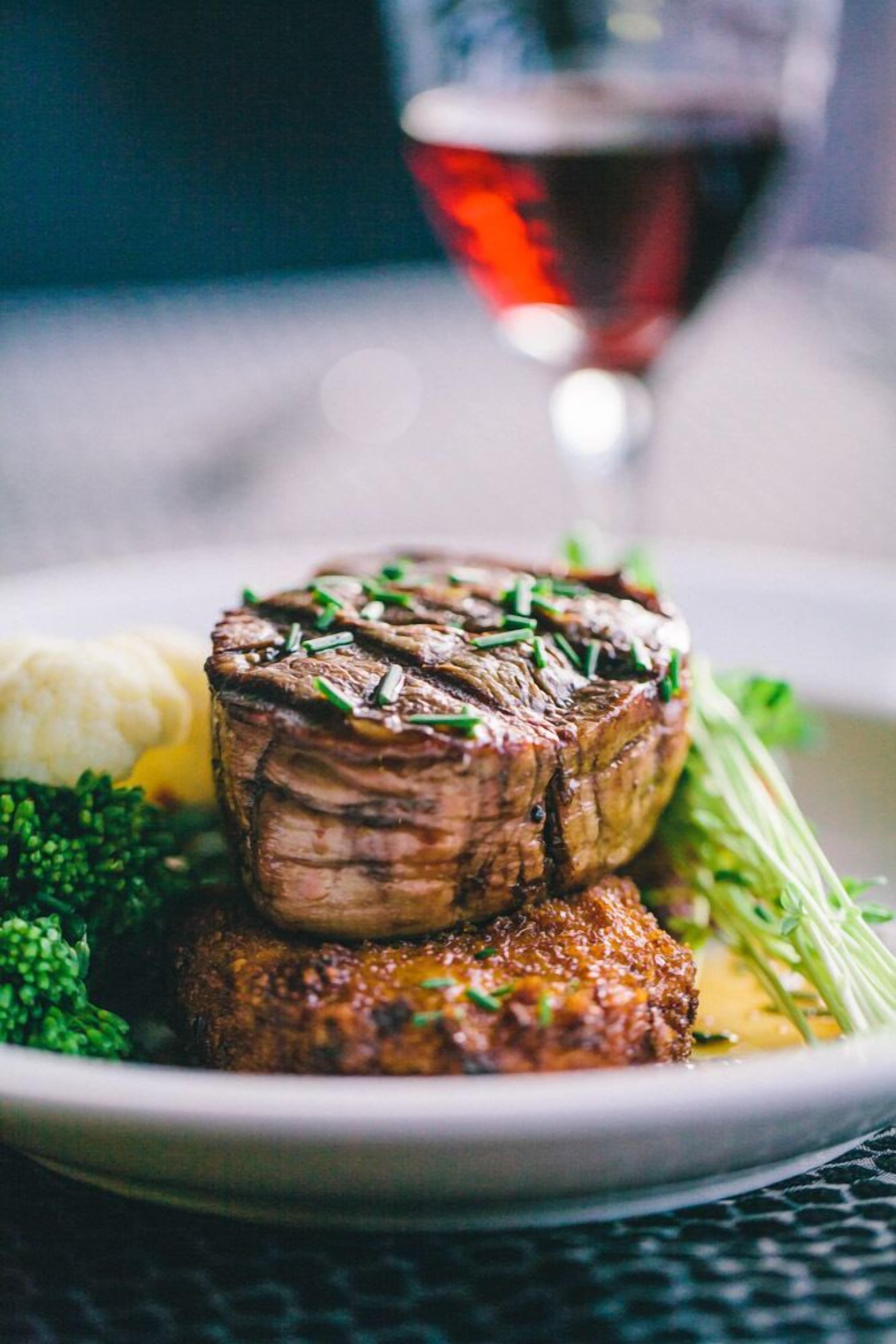 A plate with a steak, mashed potatoes, and green vegetables.