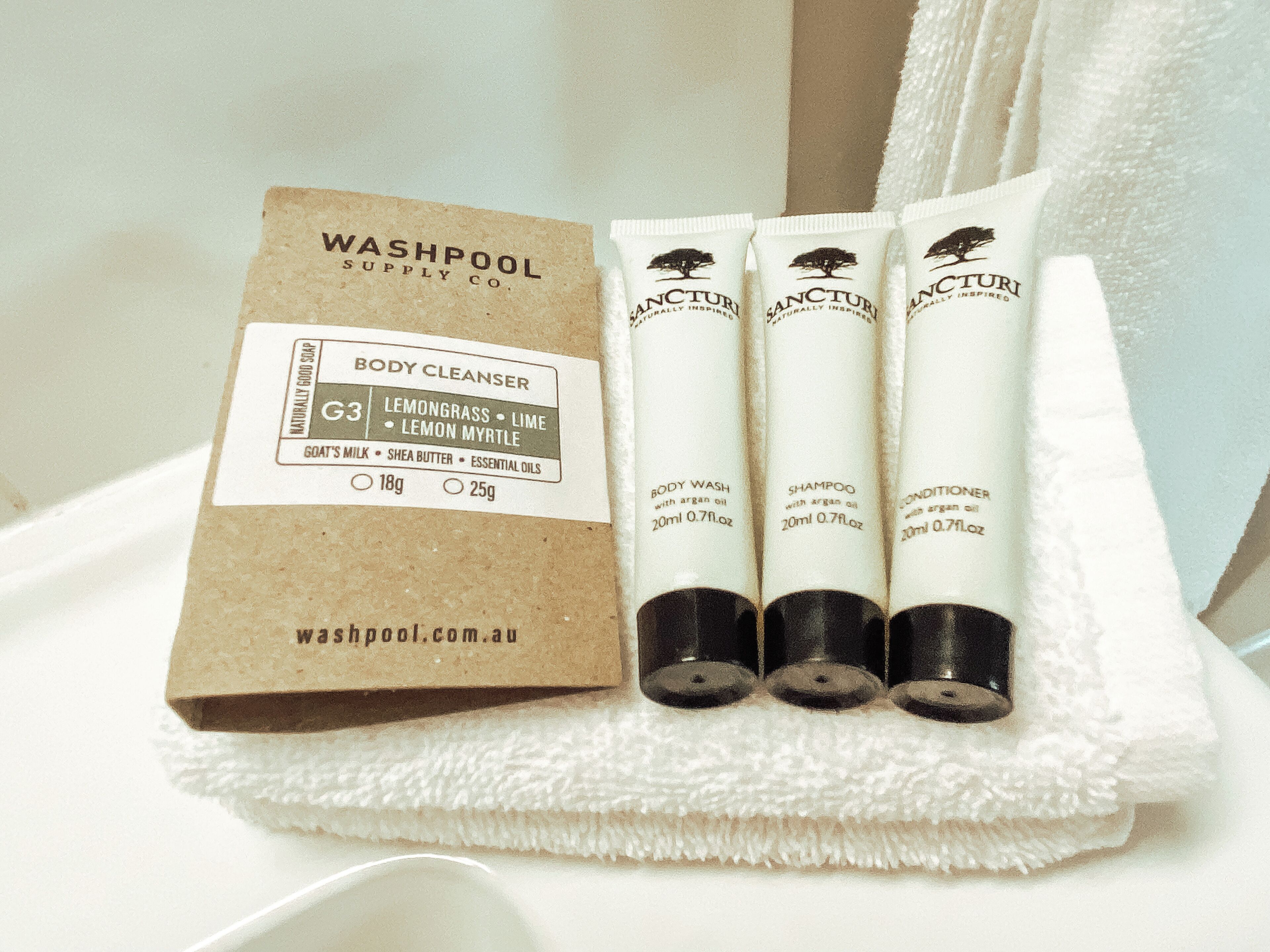 A set of body wash, shampoo, and conditioner tubes with a label for a body cleanser.