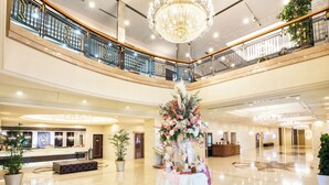 A spacious lobby with a reception desk, a large floral arrangement, and a chandelier. - Hotel Bellclassic Tokyo (Tokyo)