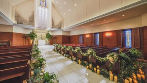 A church interior with pews, a central aisle, and floral arrangements. - Hotel Bellclassic Tokyo (Tokyo)