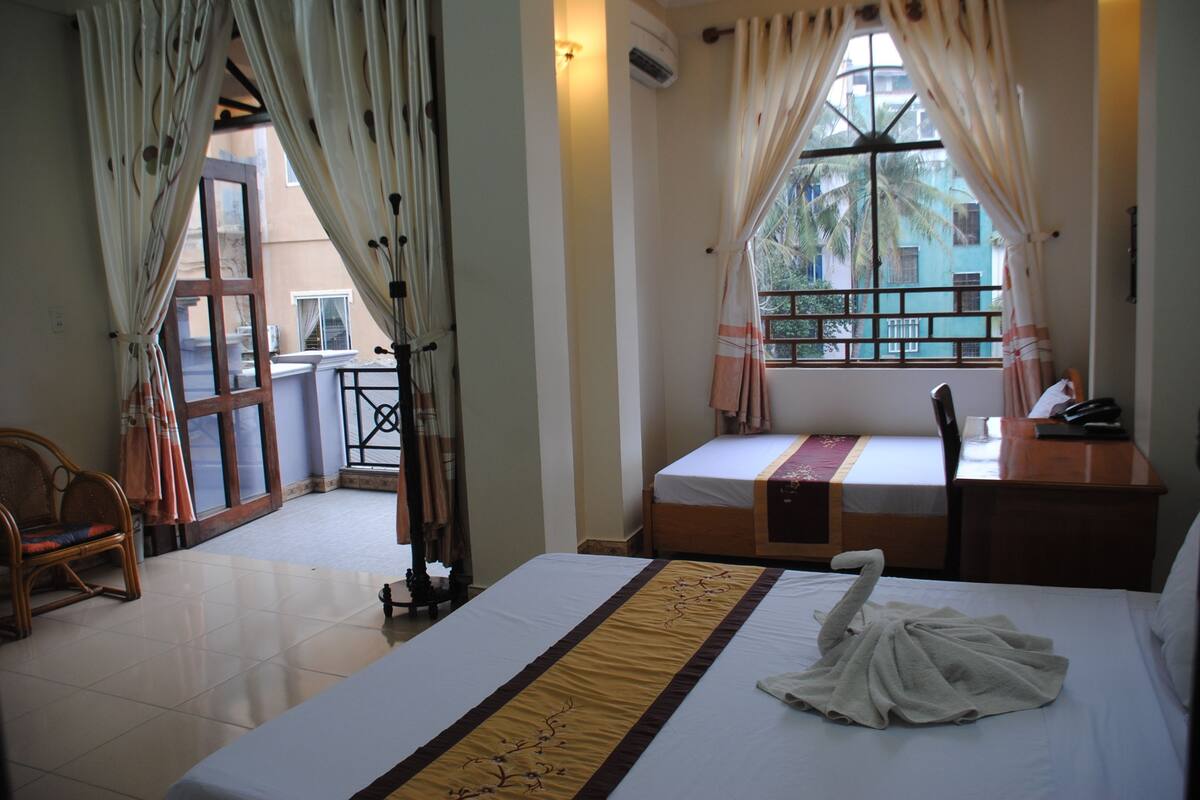 Una habitación de hotel con cama, escritorio, silla y vistas al exterior.