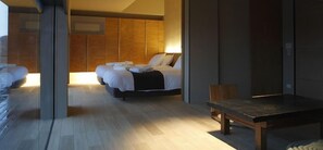 Ett modernt hotellrum med en stor säng, ett träfärgat sänggavel, ett litet bord och utsikt över staden.