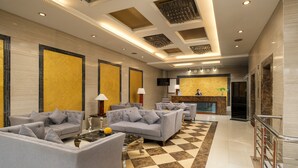 A spacious lobby with a checkered floor, grey sofas, and a reception desk. - Sunlight Guest Hotel (Puerto Princesa)